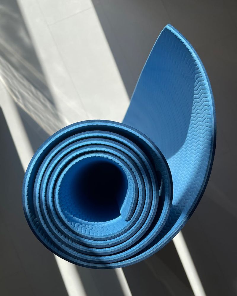 Spacious, clean room with a yoga mat on the wooden floor.